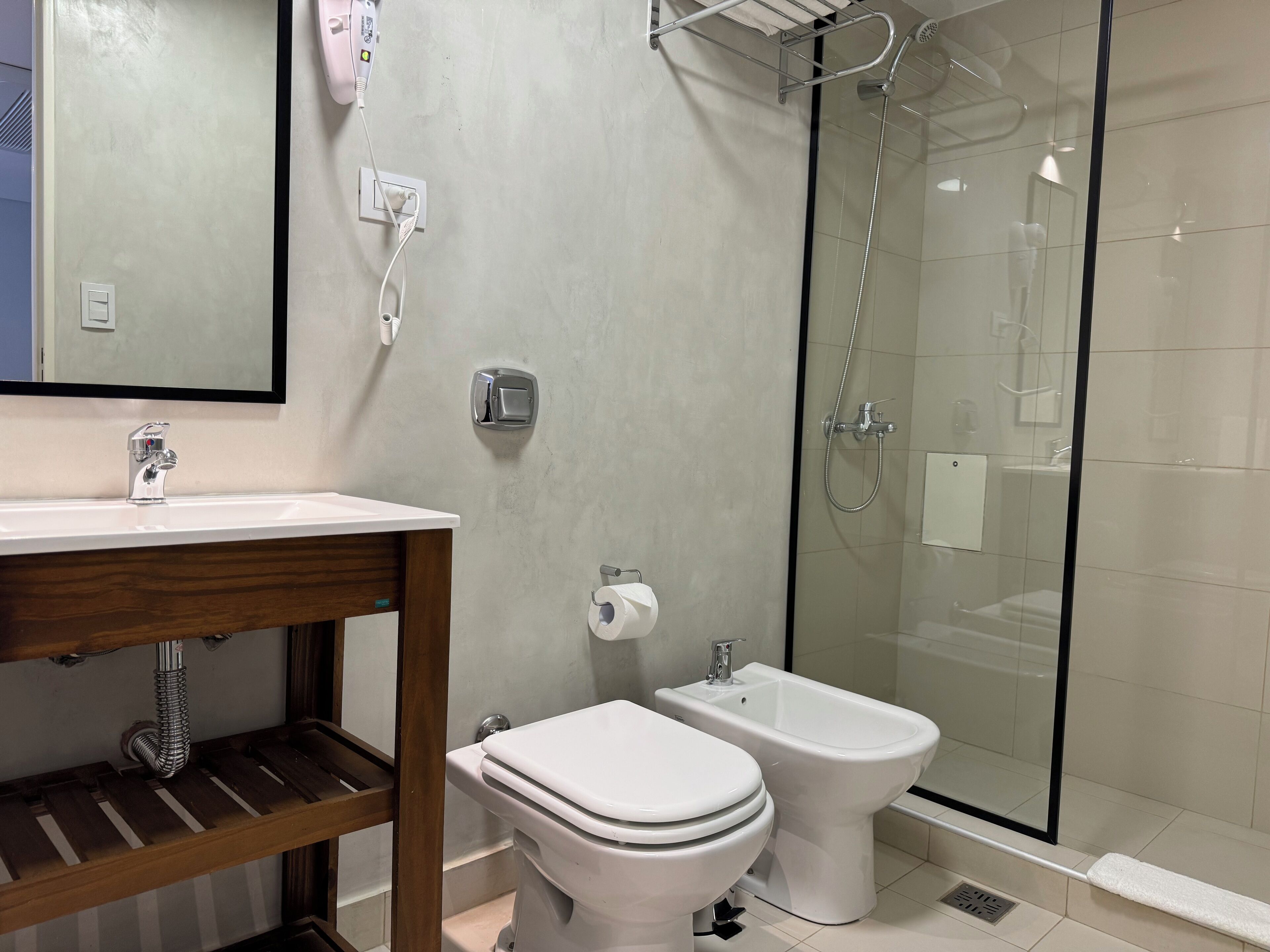 Et moderne badeværelse med toilet, bidet og brusekabine med glasvægge.