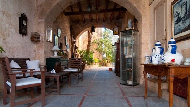 An arched hallway with rustic wooden furniture, a glass display case, and a view of the outdoors.