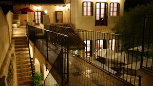 A multi-level building with a staircase, outdoor seating area, and a railing.