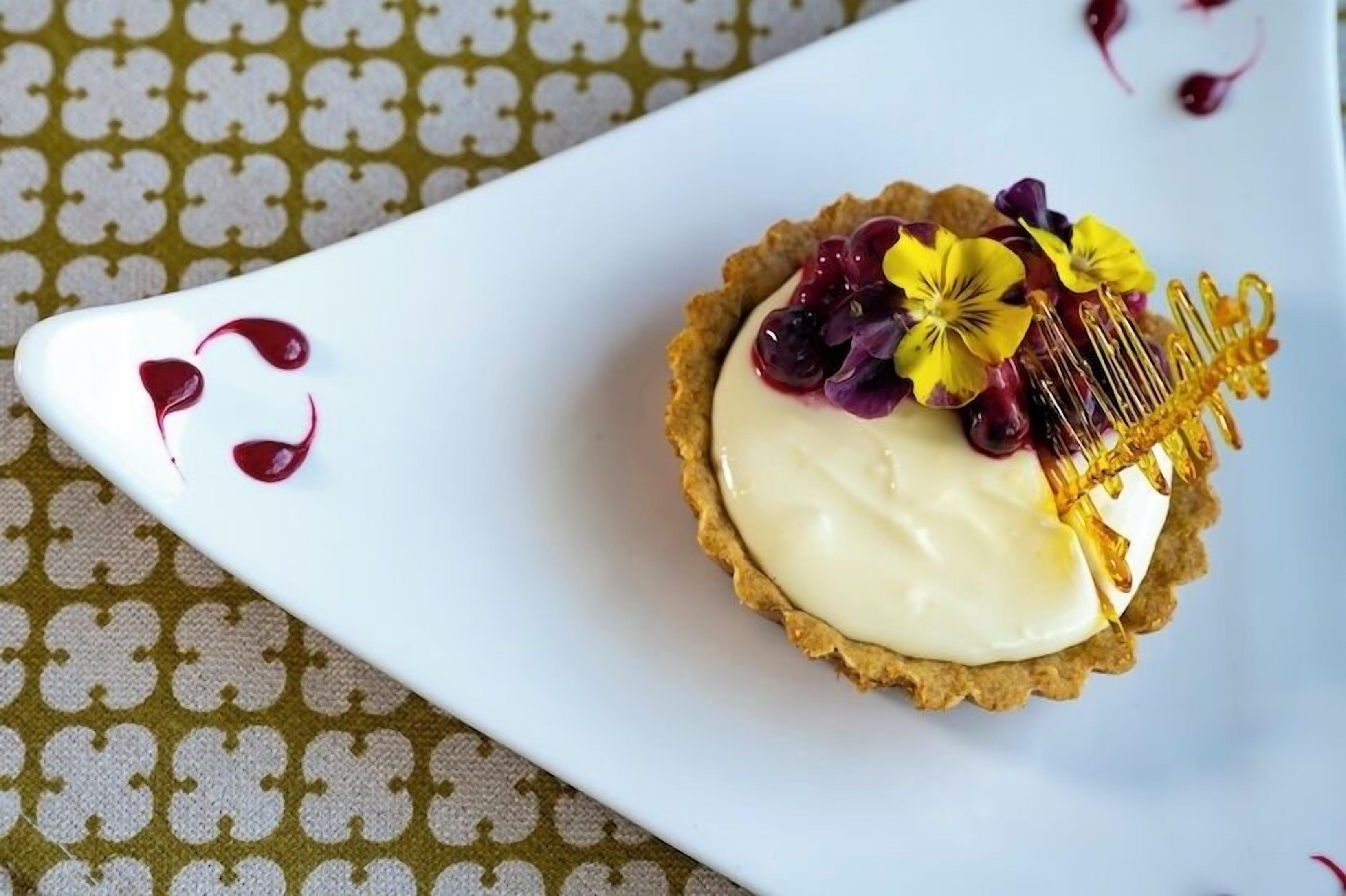 Un dessert servi sur une assiette blanche, posée sur une nappe à motifs.