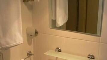 A bathroom with a sink, mirror, towel rack, and a towel hanging on the wall.