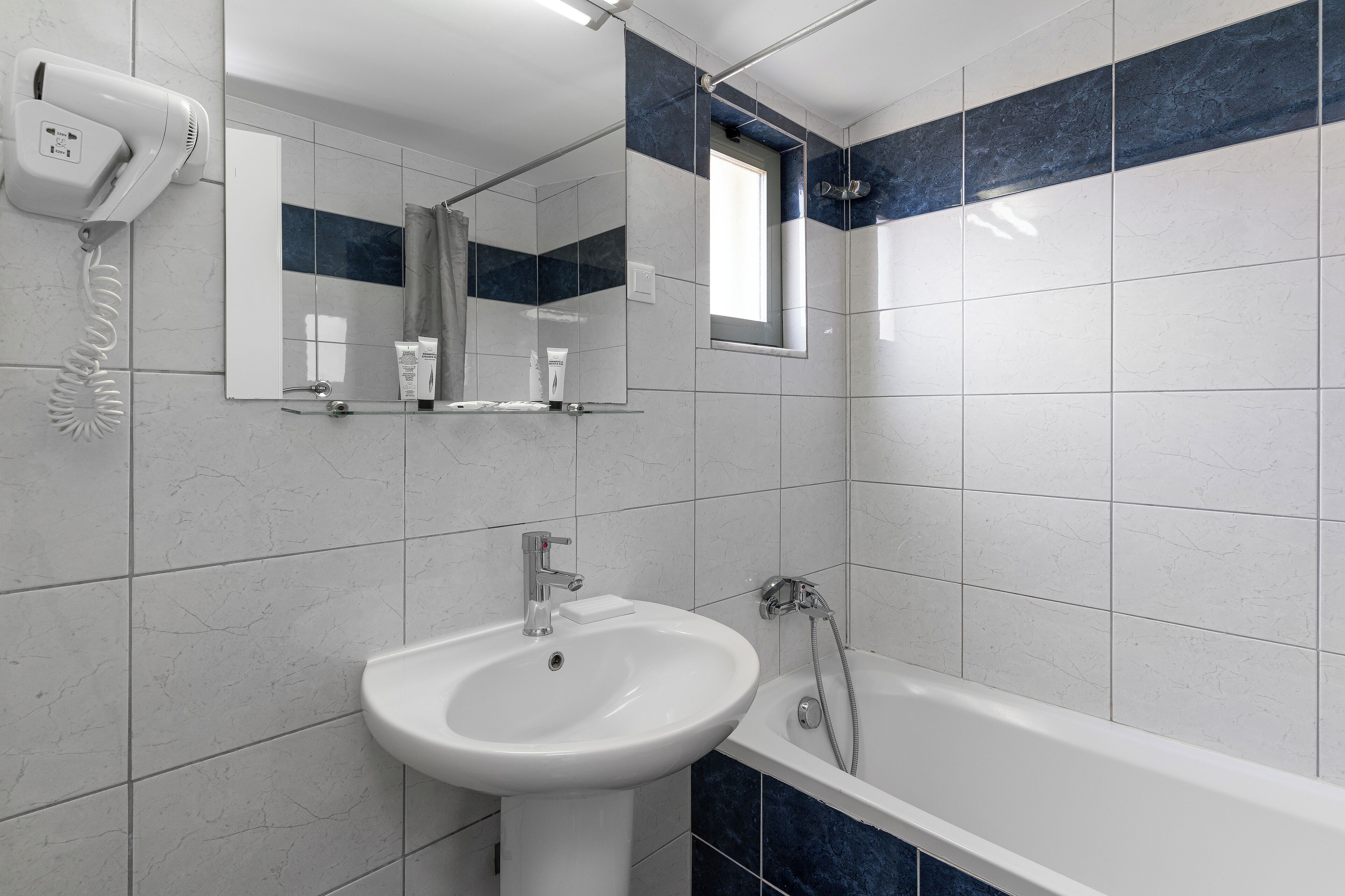 Une salle de bain avec un lavabo, un miroir et une douche.
