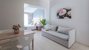 Una sala moderna con un sofá, una mesa de comedor y una planta.