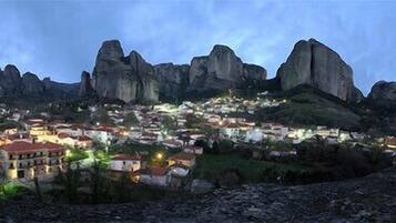 A town nestled in a valley with prominent rock formations in the background.