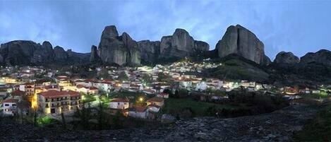 Un pueblo ubicado en un valle, con formaciones rocosas destacadas al fondo.
