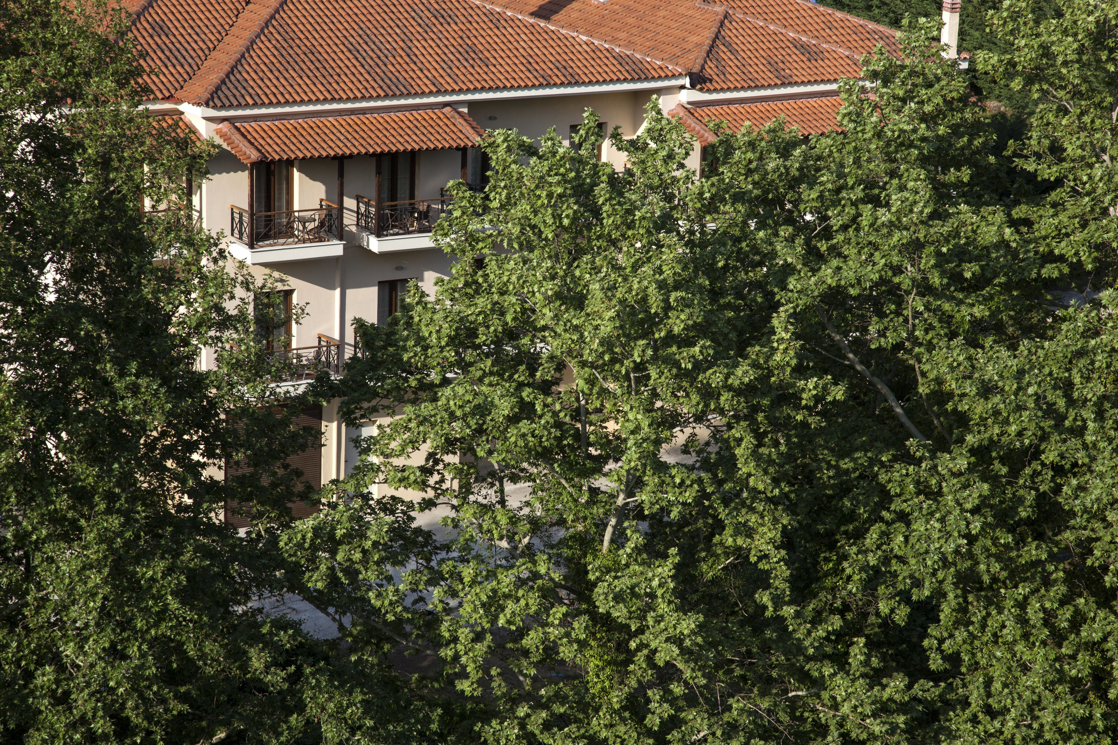 A two-story building with a red-tiled roof and balconies.