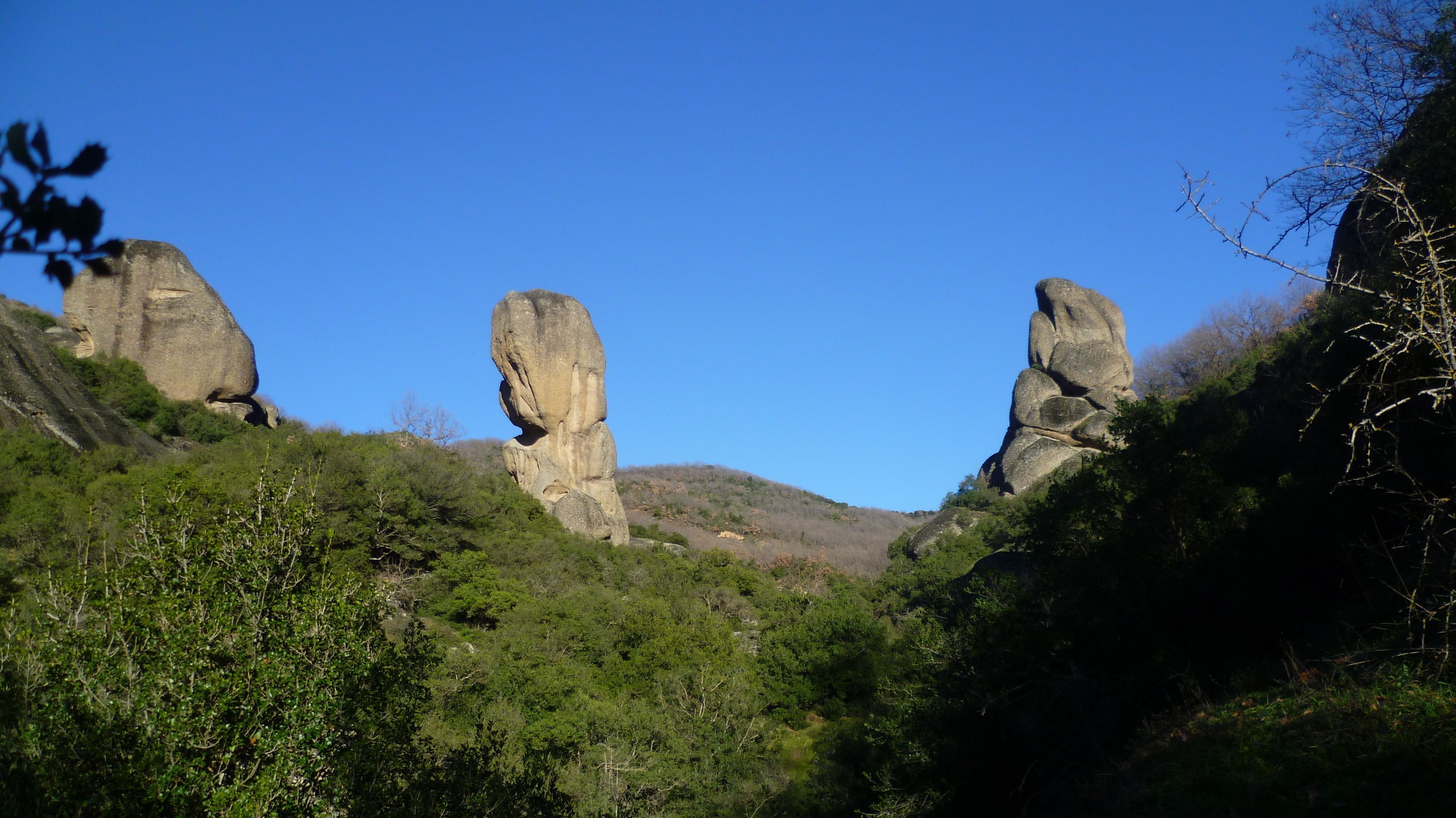 A natural landscape with three prominent rock formations.