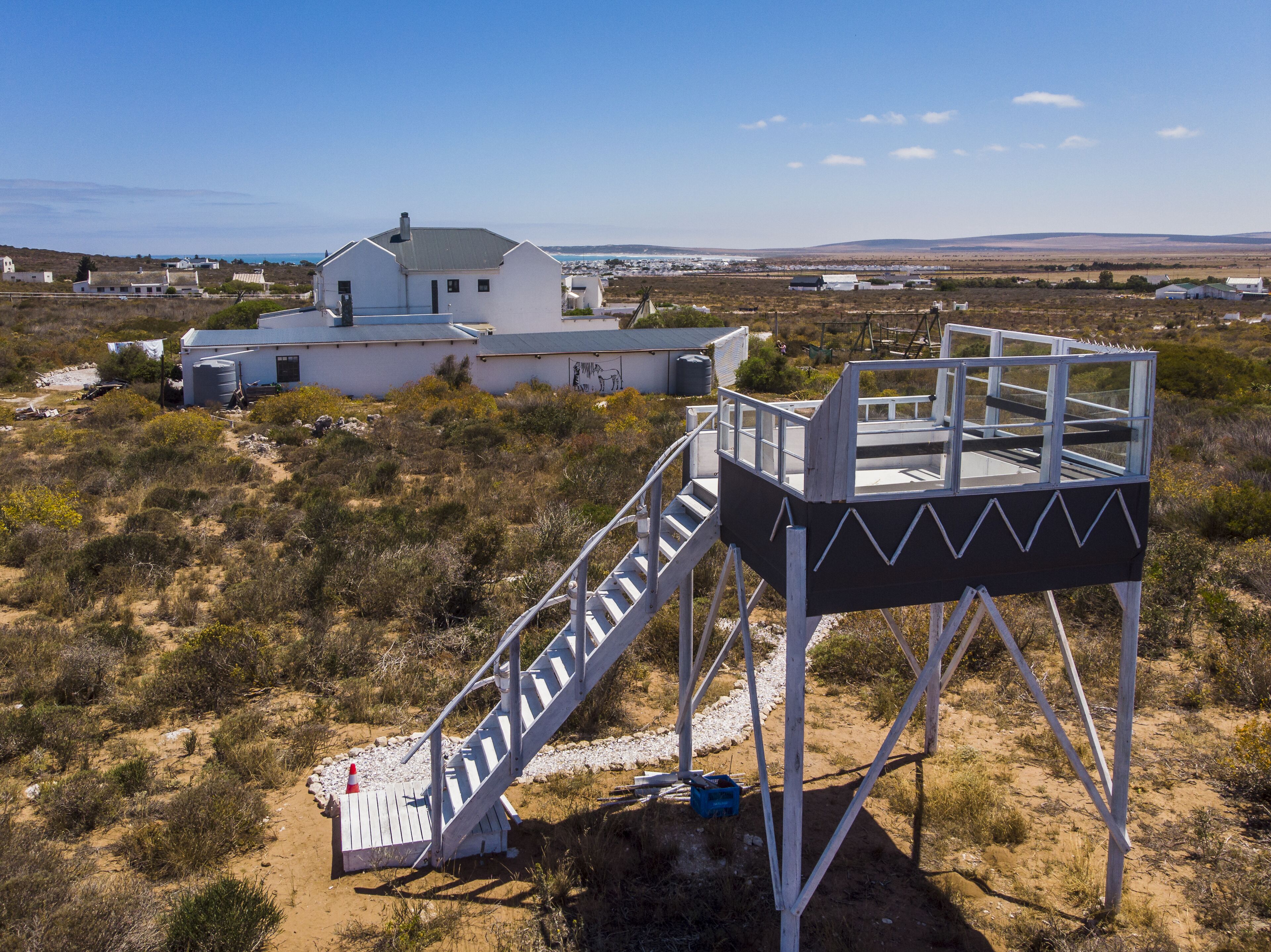 Un edificio blanco con una escalera que lleva a una plataforma panorámica.