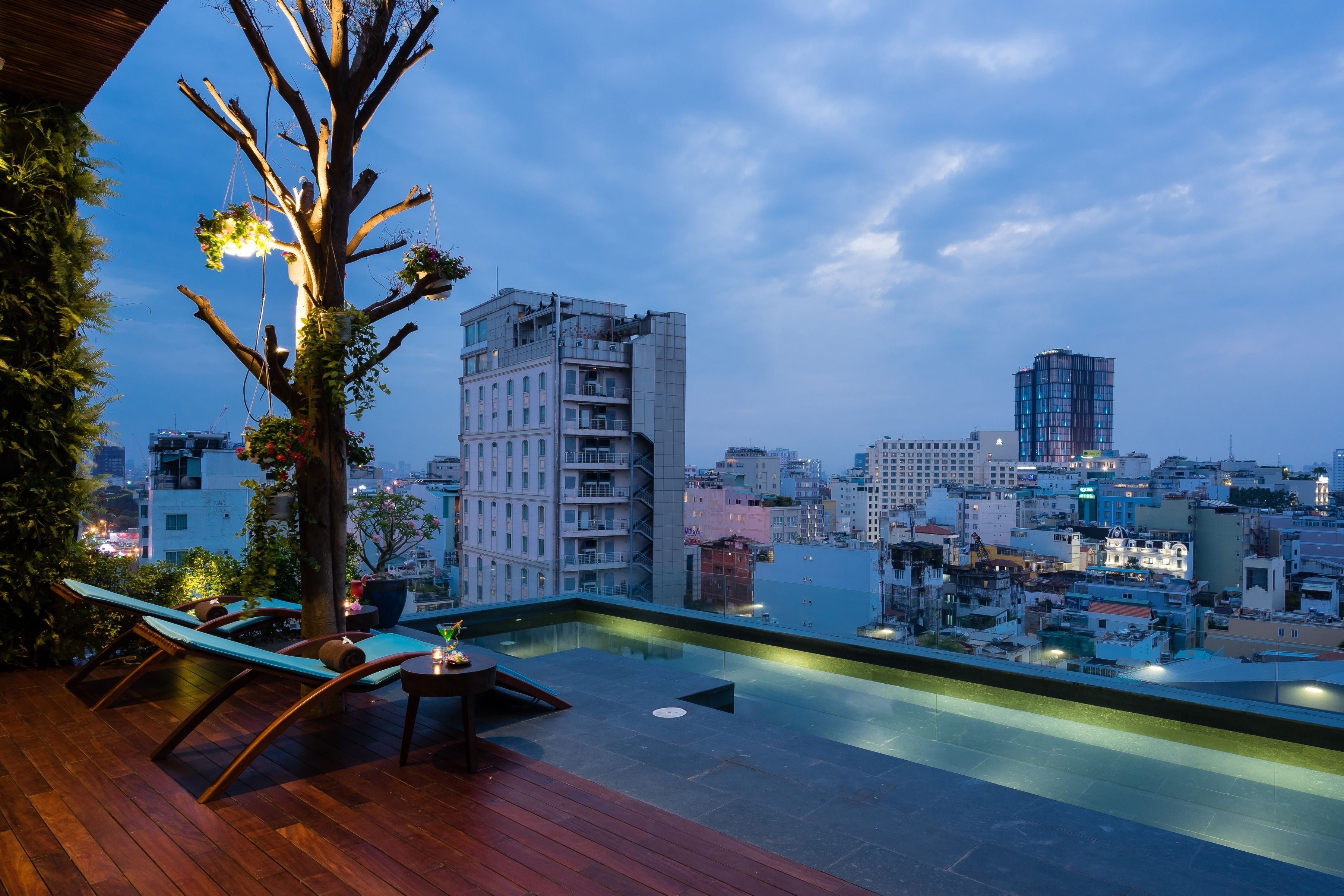 A rooftop terrace with a wooden deck, lounge chairs, and a small table.