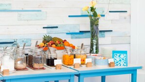 A buffet table with various food items and drink options, including jars of different sauces and a fruit display. - Hotel Baia Del Sole (Civitavecchia)