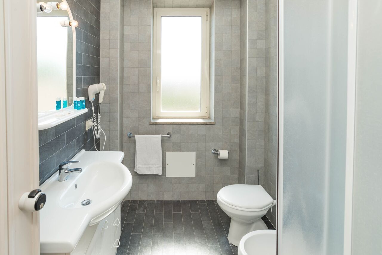 Une salle de bain avec une baignoire, des toilettes et une fenêtre.