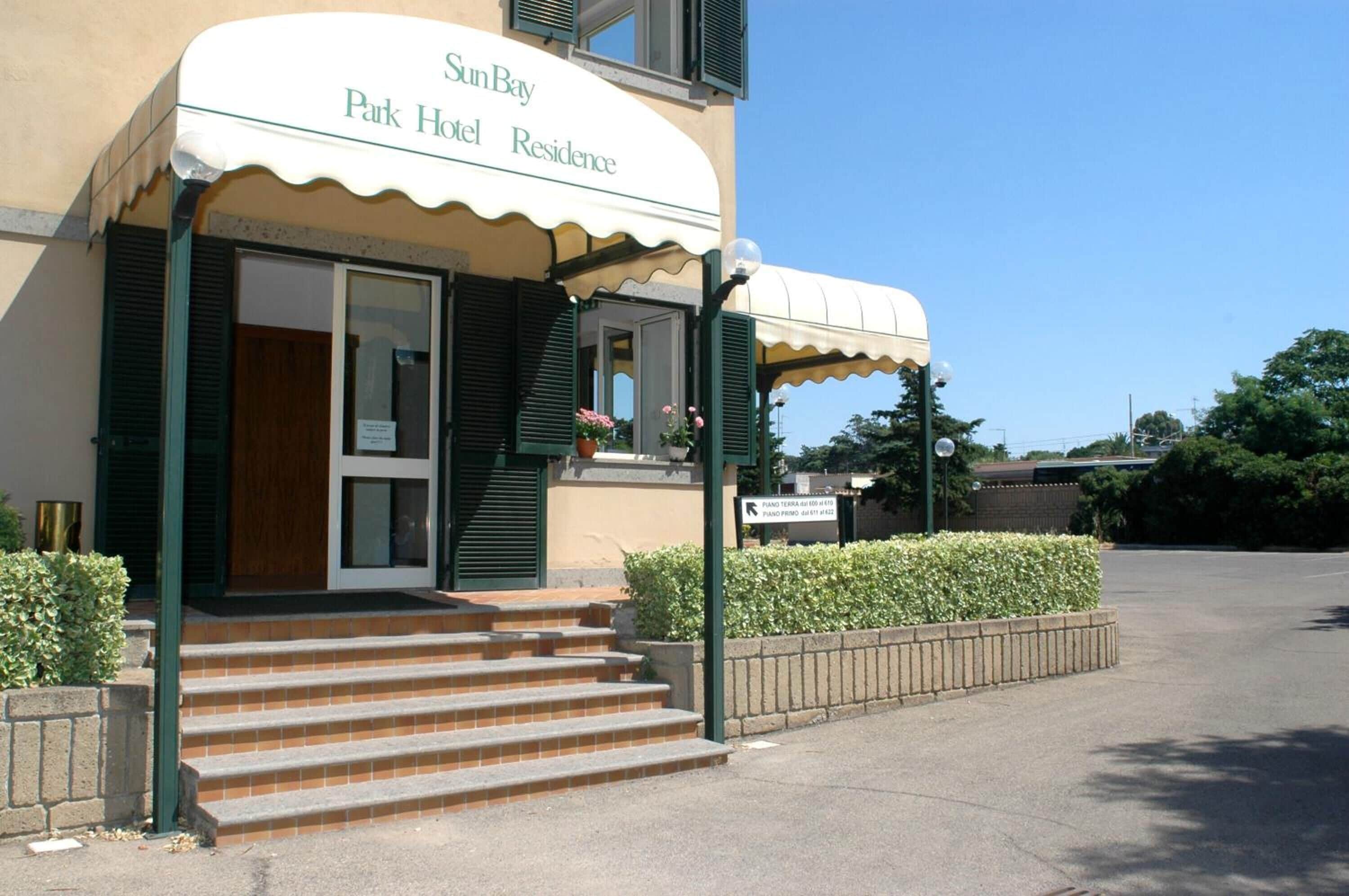 Ein Hotel Eingang mit einem Schild, das "SunBay Park Hotel Residence" zeigt.