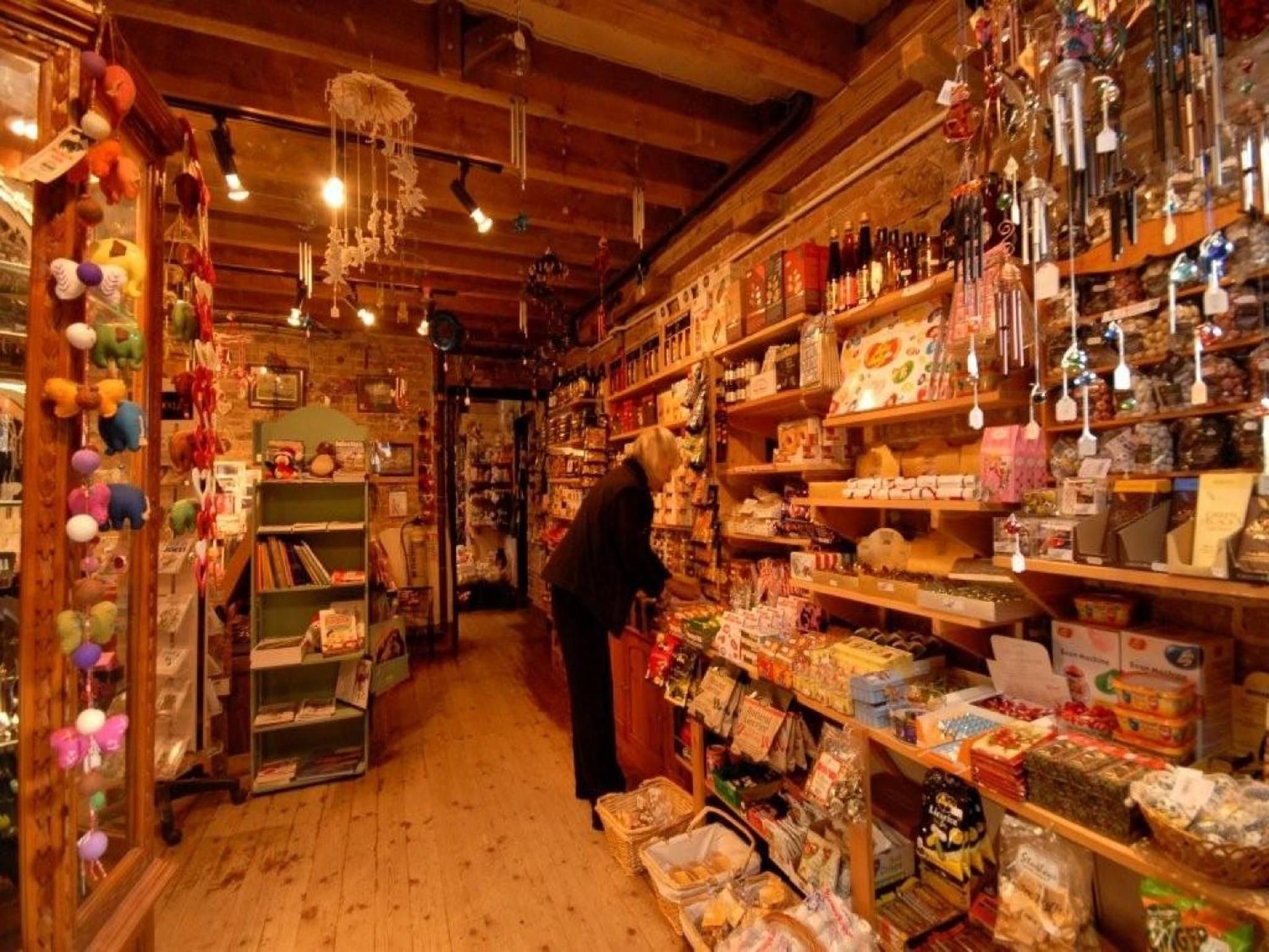A narrow aisle with shelves stocked with various packaged goods and hanging items.