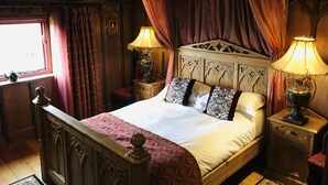 A four-poster bed with ornate headboard, two bedside tables with lamps, and a window with curtains. - Wolds Village (Driffield)