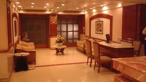 A hotel lobby with a reception desk, seating area, and a large window. - Hotel Solitaire (Mumbai)