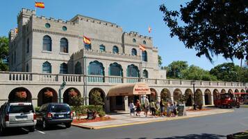 A historic building with a museum entrance, arched windows, and flags.