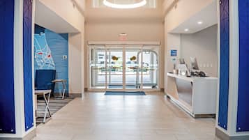 A reception area with a desk, chairs, and a glass door leading outside.