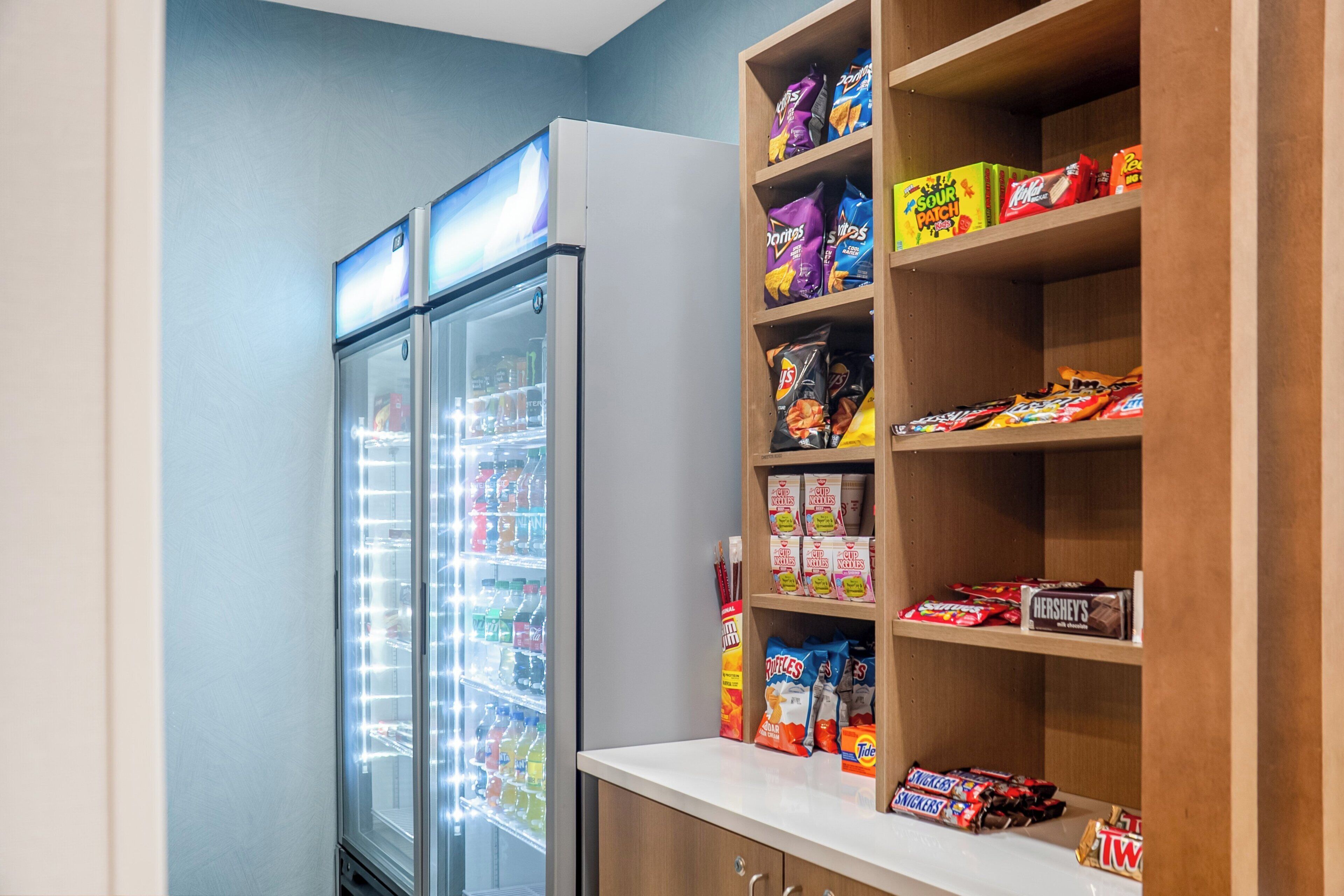 A vending machine with snacks and a shelf stocked with various packaged foods.