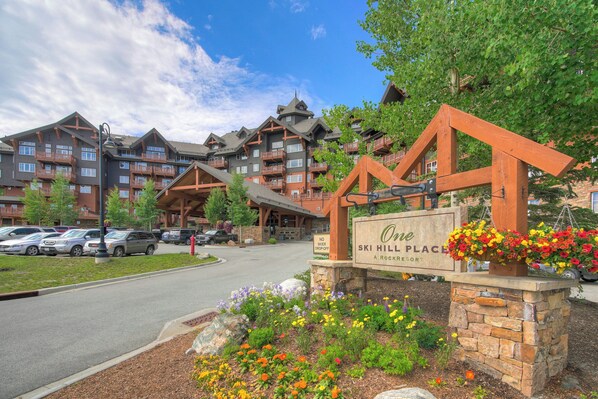 Un hôtel à plusieurs étages, doté d’une entrée en pierre et d’une enseigne indiquant : « One Ski Hill Place, un établissement Rock Resort ».