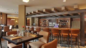 Um restaurante com área de bar, vigas de madeira no teto e banquetas.