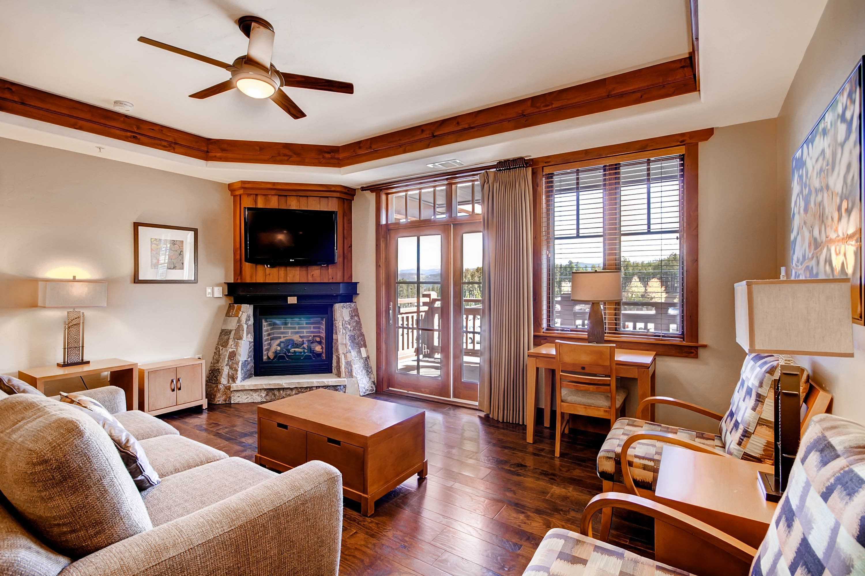 Una sala de estar acogedora con chimenea, muebles de madera y televisor.