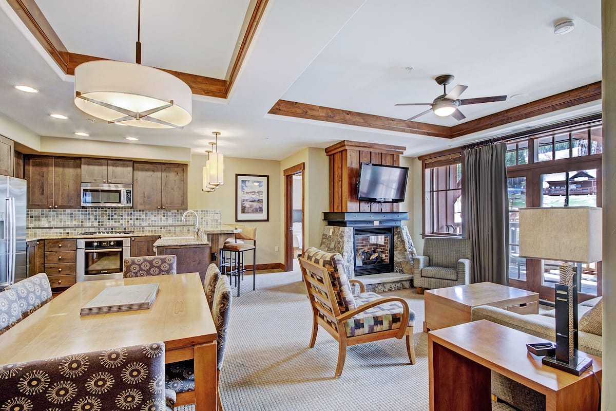 A spacious living area with a fireplace, comfortable seating, and a television.