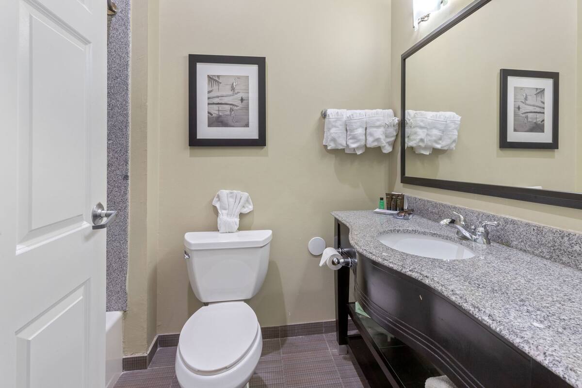 Ein Badezimmer mit Toilette, Waschbecken und zwei gerahmten Bildern an der Wand.