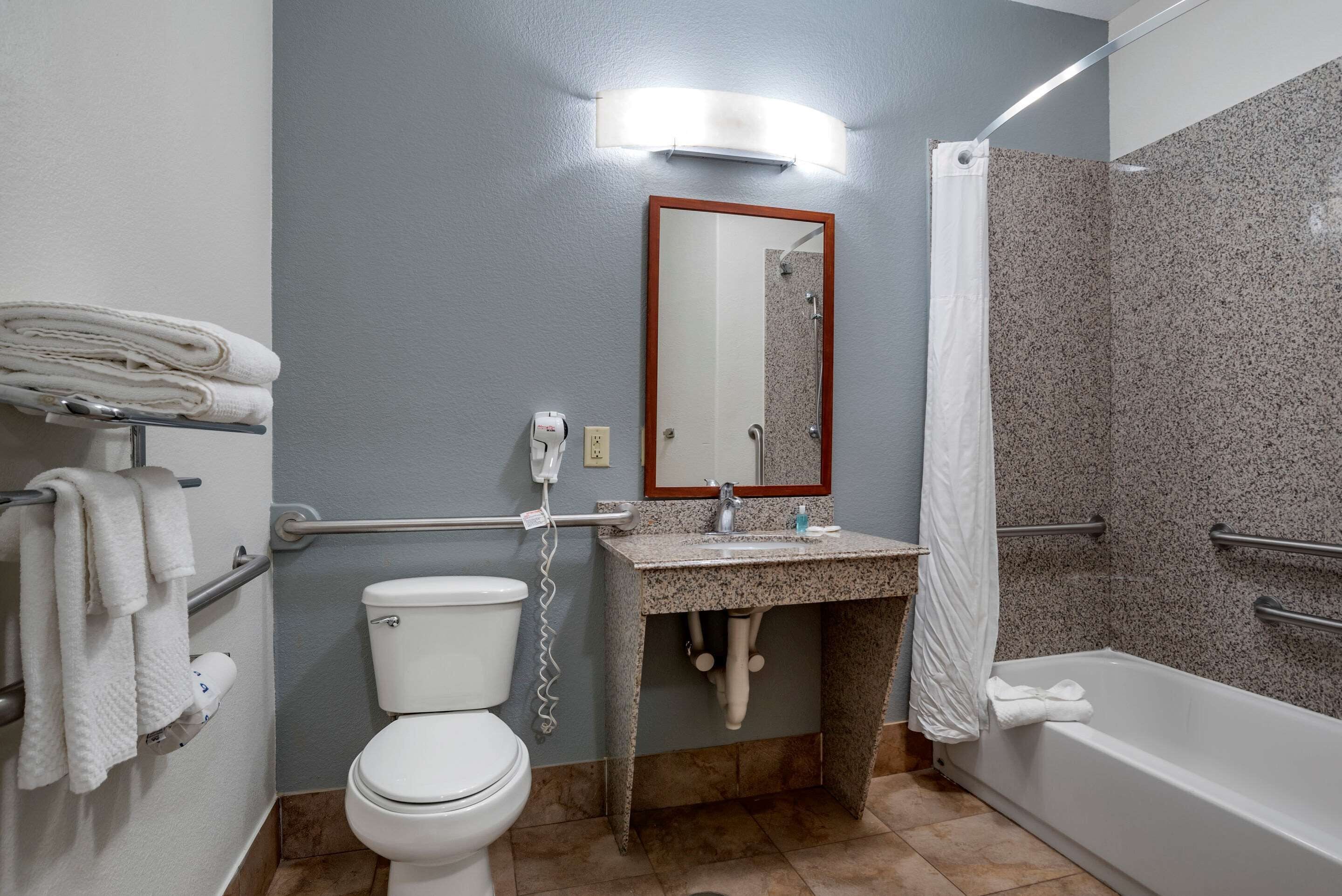 A bathroom with a toilet, sink, and shower.