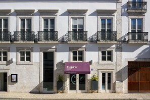 Un edificio con un llamativo toldo 'Inspira', varias ventanas y balcones.