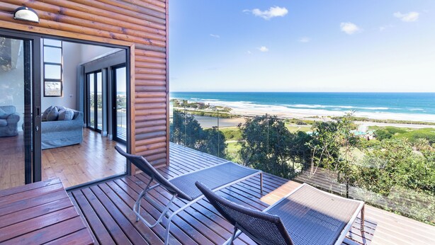 A wooden deck with lounge chairs overlooking a beach. - Boardwalk Lodge - self-catering (Wilderness)