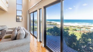 A spacious balcony with large windows overlooking a beach and ocean. - Boardwalk Lodge - self-catering (Wilderness)