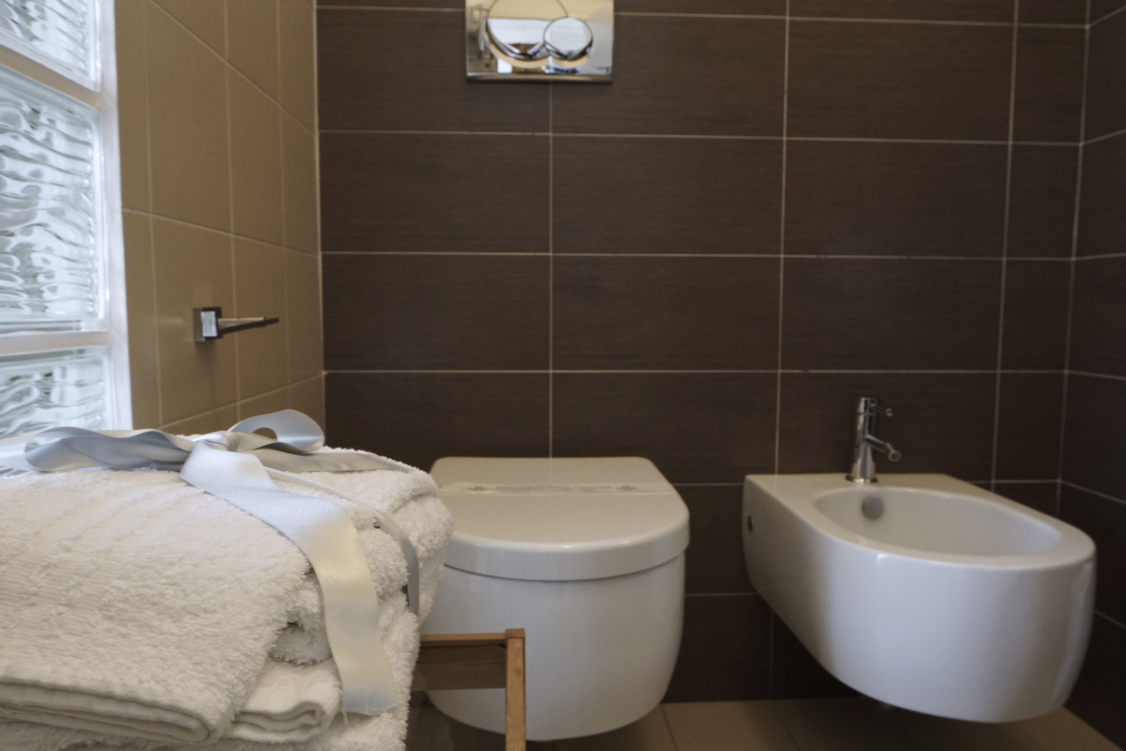 Ein Badezimmer mit Toilette, Bidet und Handtuchhalter.