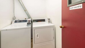 A laundry area with two washing machines and a red door labeled "Guest Laundry". - Econo Lodge Edson - 2nd Ave (Edson)