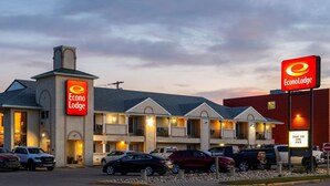 A motel with multiple units, a prominent EconoLodge sign, and a parking area with several cars. - Econo Lodge Edson - 2nd Ave (Edson)