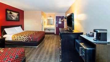 Une chambre d’hôtel avec deux lits, une télévision, un bureau avec une machine à café et un four à micro-ondes.