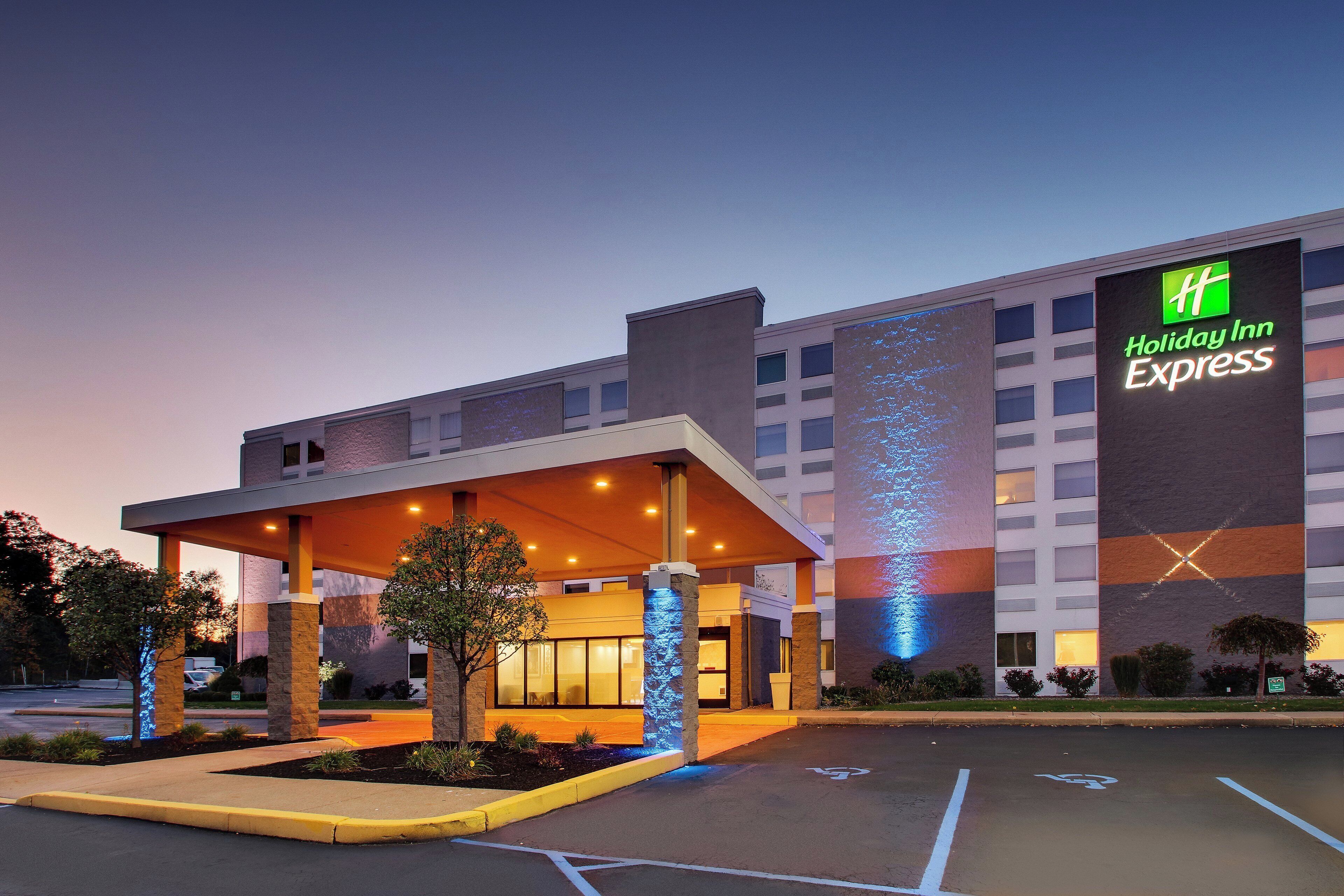 Un hotel Holiday Inn Express con entrada techada y estacionamiento.