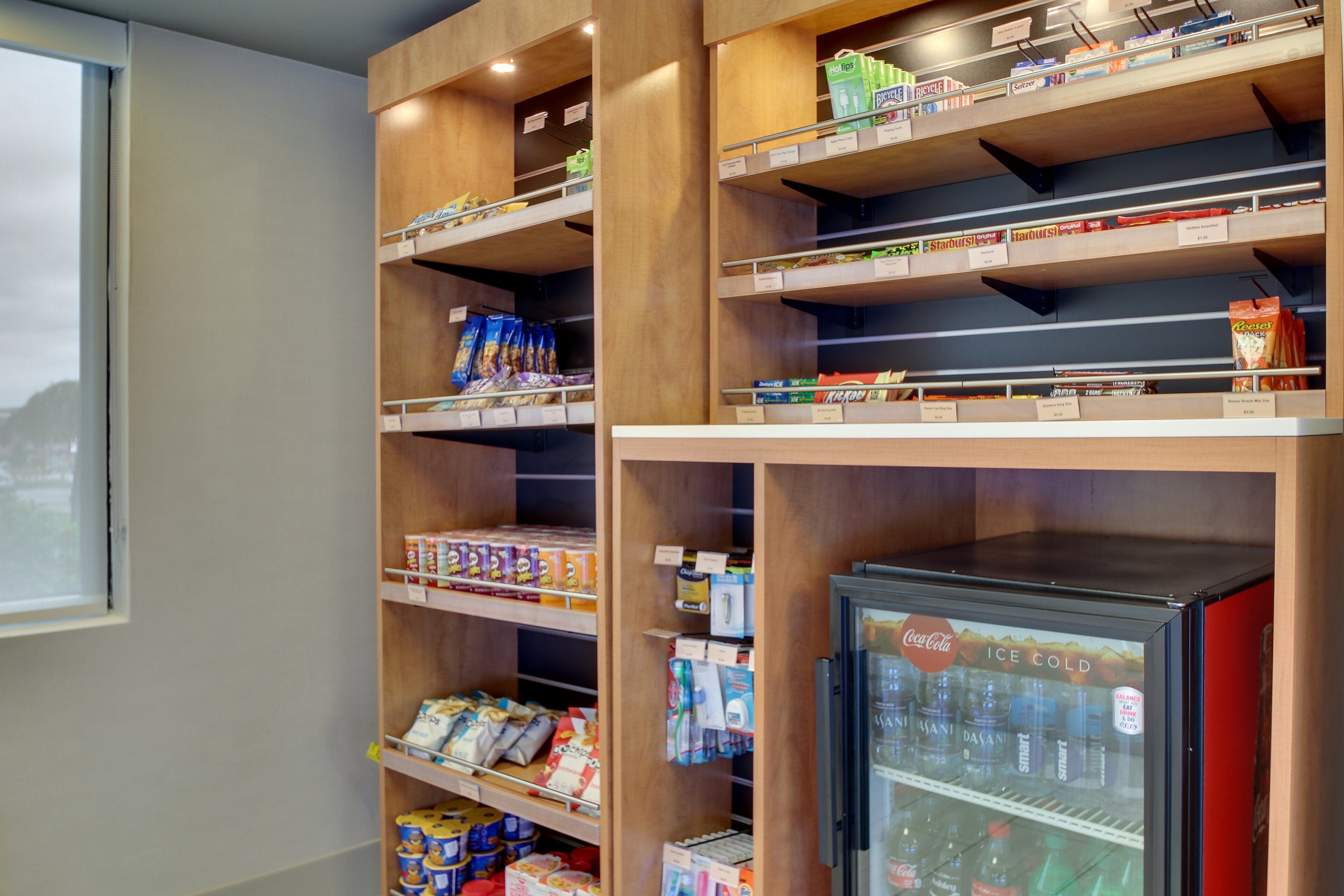 A vending machine stocked with beverages and a refrigerator.