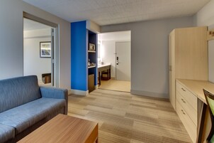 Una sala moderna con un sofá, una mesa de centro de madera y un mueble.