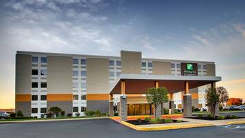 A Holiday Inn Express building with a covered entrance, multiple windows, and a parking lot.