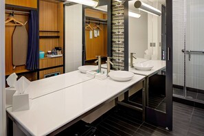 Een douche, designer toiletartikelen, een haardroger, handdoeken