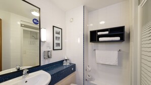 A bathroom with a sink, toilet, and a shower area.