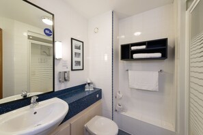 A bathroom with a sink, toilet, and a shower area.