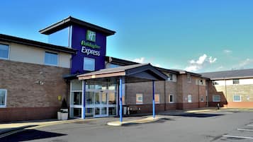 Edificio de Holiday Inn Express con entrada cubierta y estacionamiento.