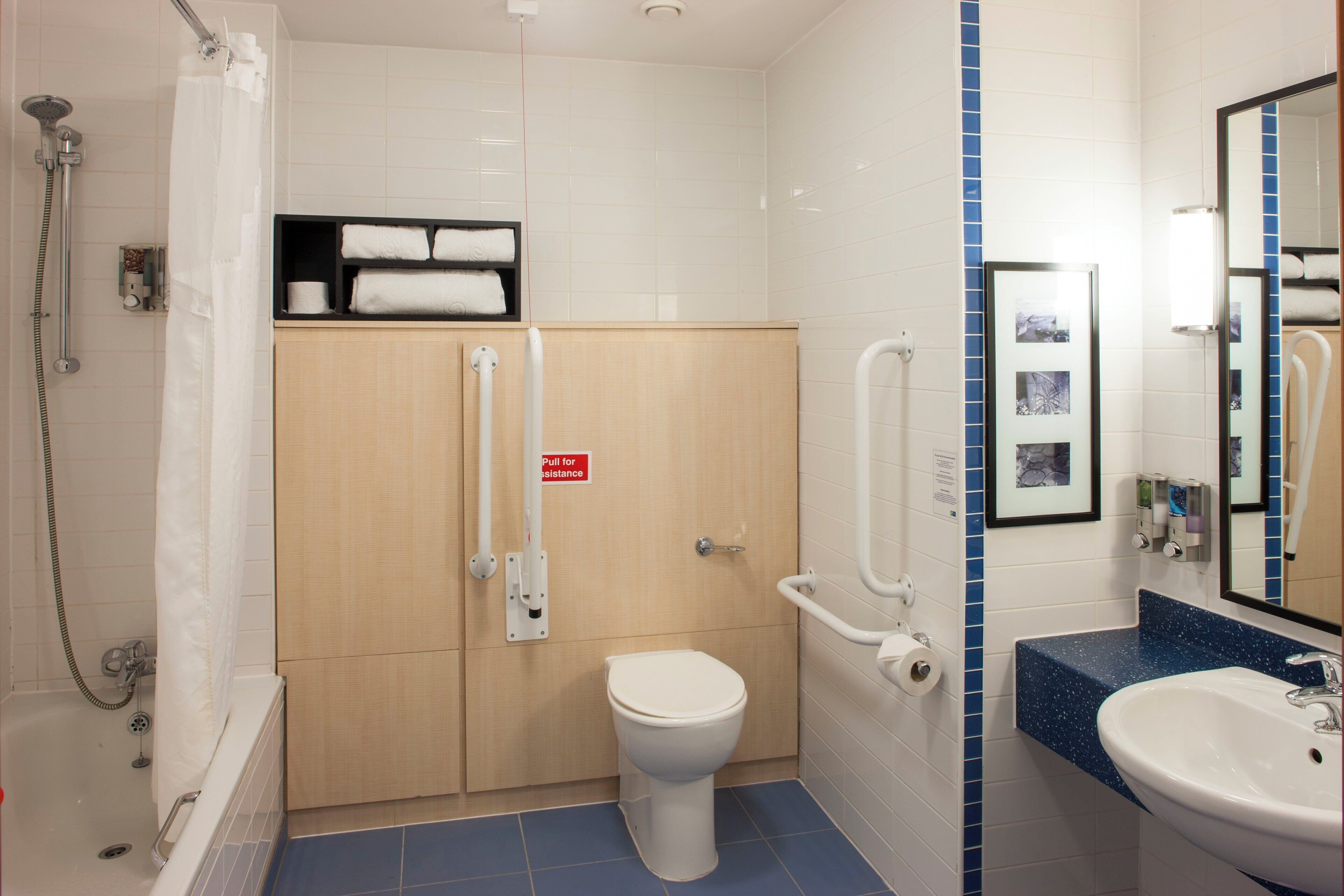 A bathroom with a shower, toilet, and sink.