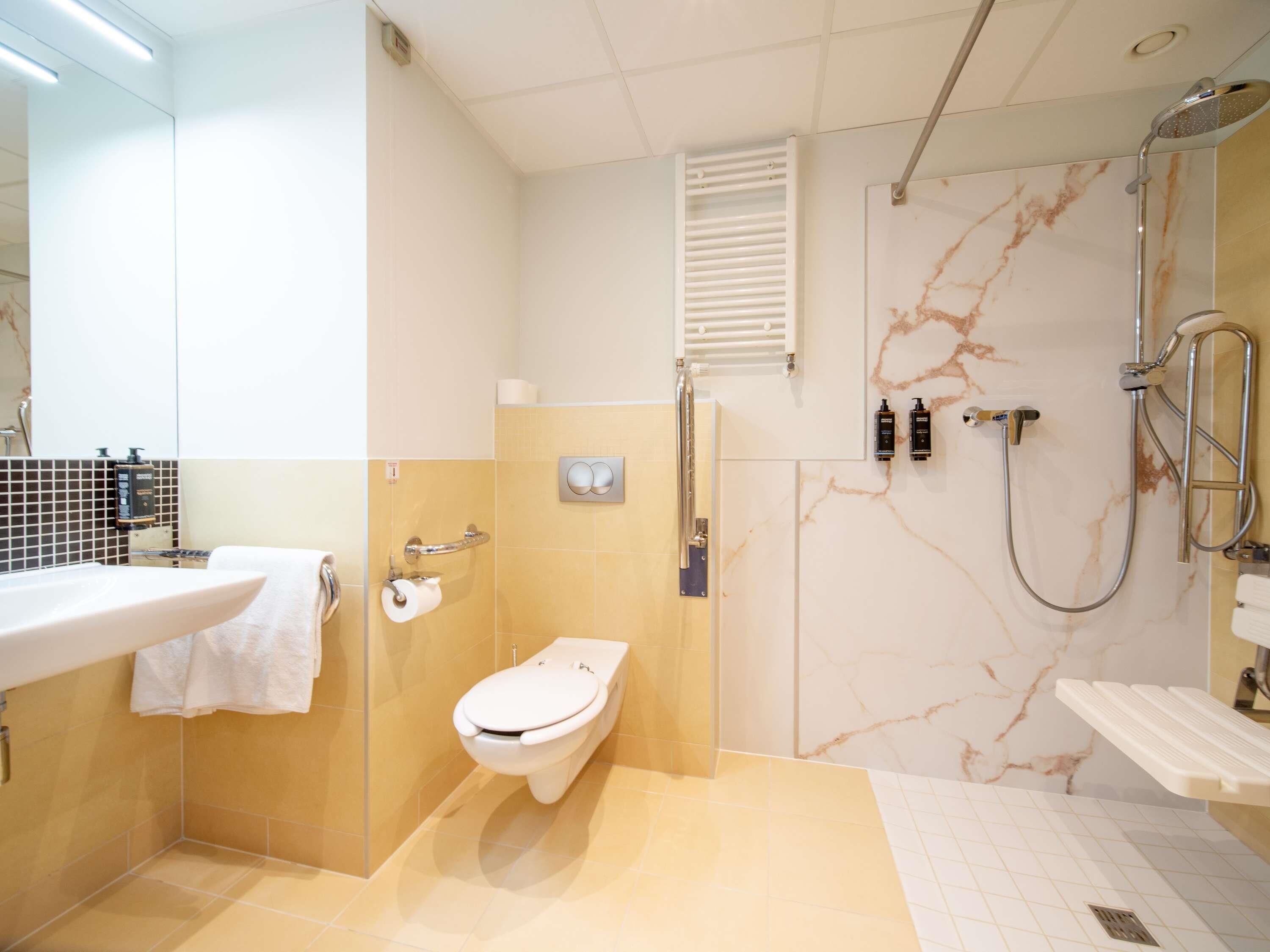 A modern bathroom with a toilet, sink, and shower.