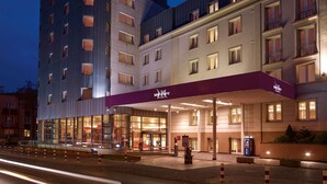 Un hotel con fachada moderna, una entrada destacada y un exterior bien iluminado.
