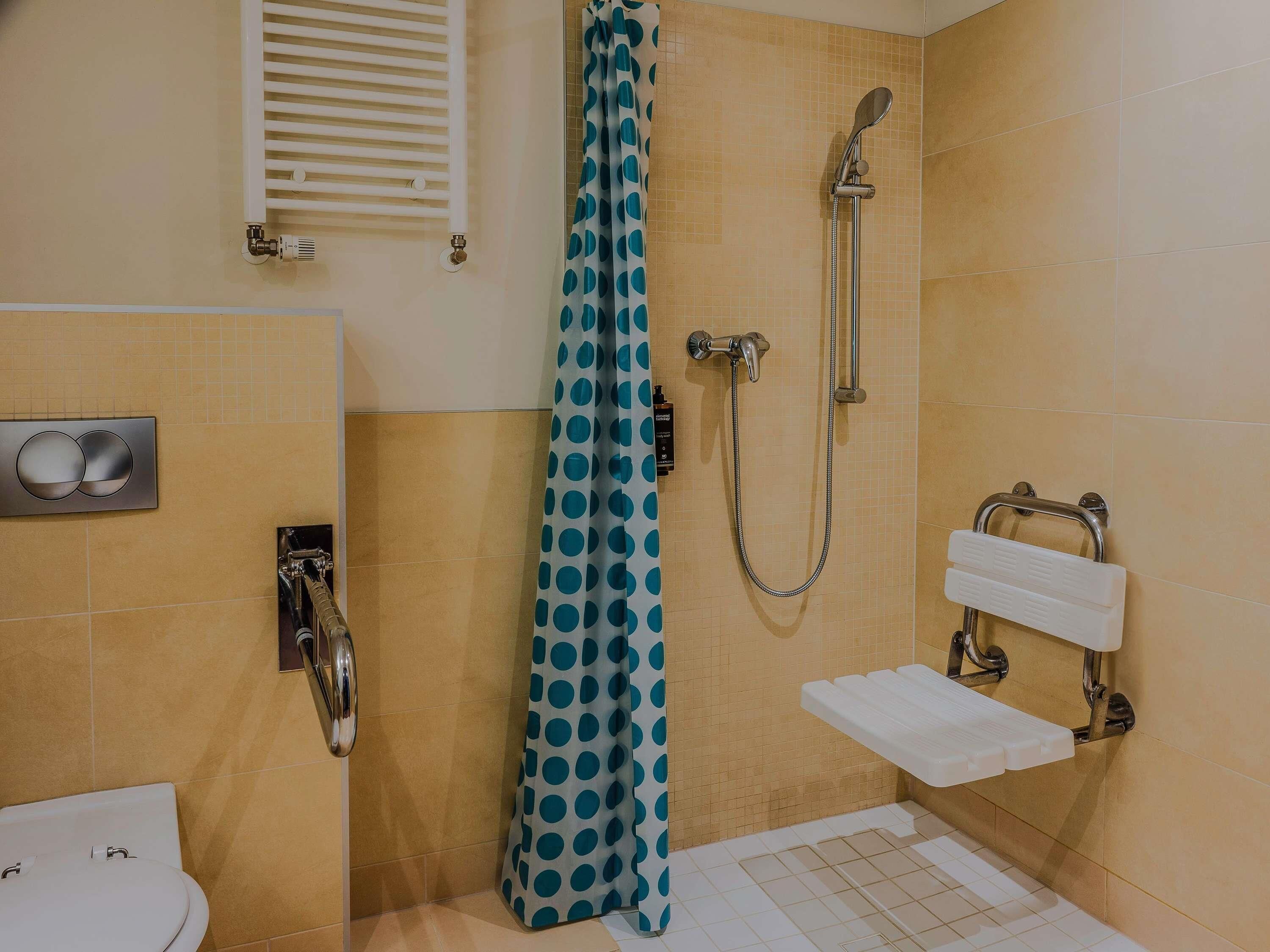 Ein Badezimmer mit Dusche, Toilette und Handtuchhalter.