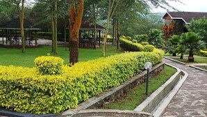 A landscaped garden with neatly trimmed hedges, a stone pathway, and a gazebo. - Elementaita Country Lodge (Nakuru)