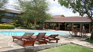 A pool area with lounge chairs and a covered seating area. - Elementaita Country Lodge (Nakuru)