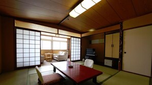 A traditional Japanese room with tatami flooring, a low wooden table, and sliding doors. - Washuzan Shimoden Hotel (Kurashiki)